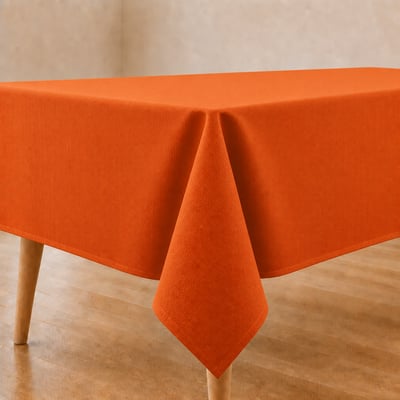 Oranje tafelkleed op gedekte eettafel in lichte eetkamer