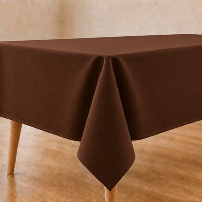 Bruin tafelkleed op gedekte eettafel in warme, natuurlijke tinten